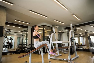 Güzel genç bir kadın spor salonunda yedek kulübesinde eğitim görüyor.
