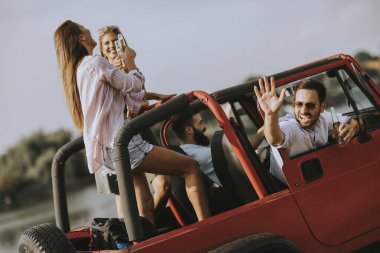 Bir grup mutlu genç yolculuğun tadını çıkarıyor.