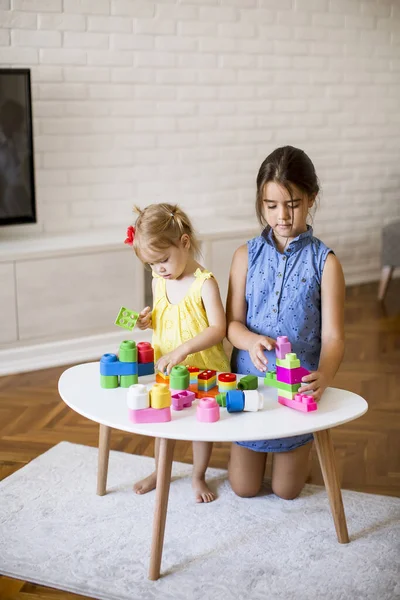 Δύο Χαριτωμένα Κοριτσάκια Παίζουν Τουβλάκια Στο Τραπέζι — Φωτογραφία Αρχείου