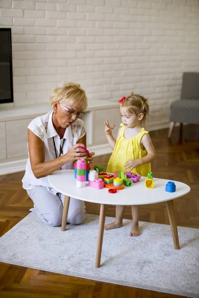 Großmutter Und Süßes Kleines Mädchen Spielen Mit Plastikklötzen Zimmer — Stockfoto