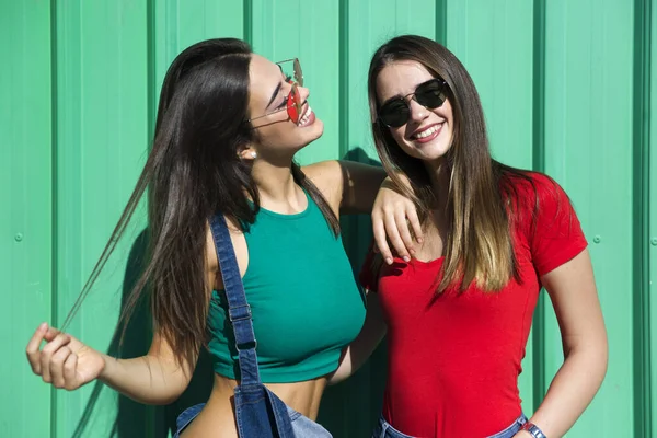在炎热的夏日 两名年轻貌美的女子站在绿墙边 — 图库照片