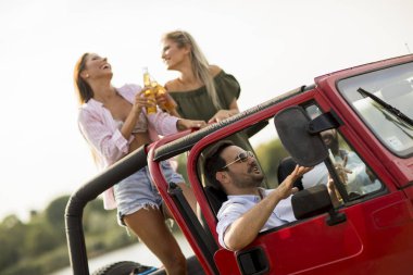 Bir grup mutlu genç yolculuğun tadını çıkarıyor.