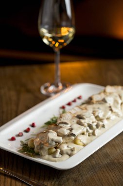 Krem mantar soslu rendelenmiş gnocchi soslu tavuk eti ve masada beyaz şaraplı füme peynir.