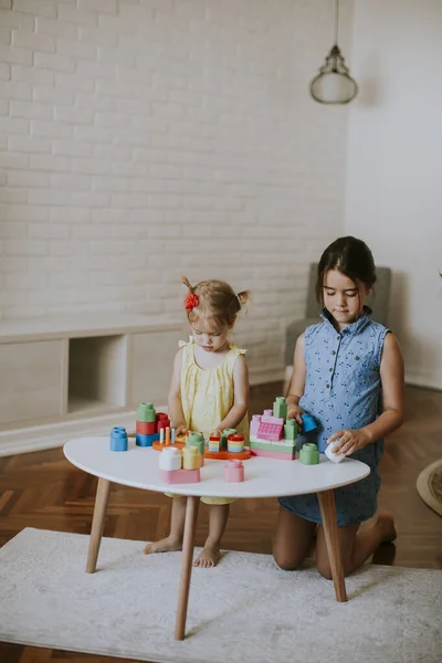 Dos Niñas Lindas Juegan Con Bloques Mesa Habitación —  Fotos de Stock