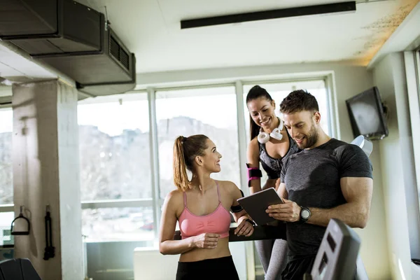 Jovens Mulheres Discutindo Progresso Treino Tablet Digital Com Instrutor Fitness — Fotografia de Stock