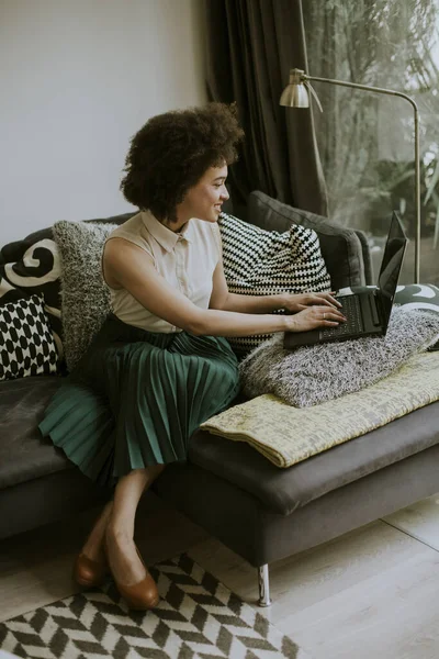 Menina Bonita Com Cabelo Encaracolado Trabalhar Caderno Enquanto Senta Sofá — Fotografia de Stock