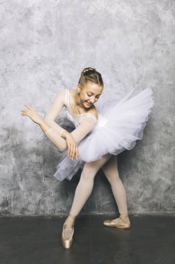 Yaşlı taşra duvarına karşı klasik bale yapan genç bir balerin.