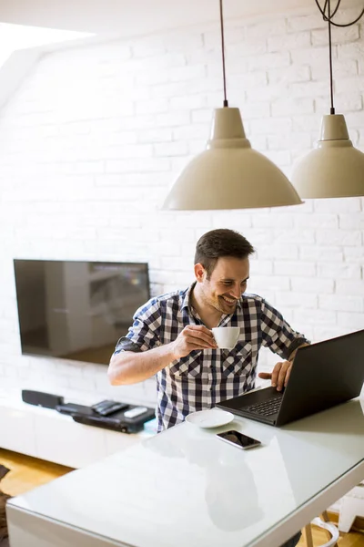 Snygg Ung Man Sitter Köksbord Hemma Och Använder Laptop Och — Stockfoto