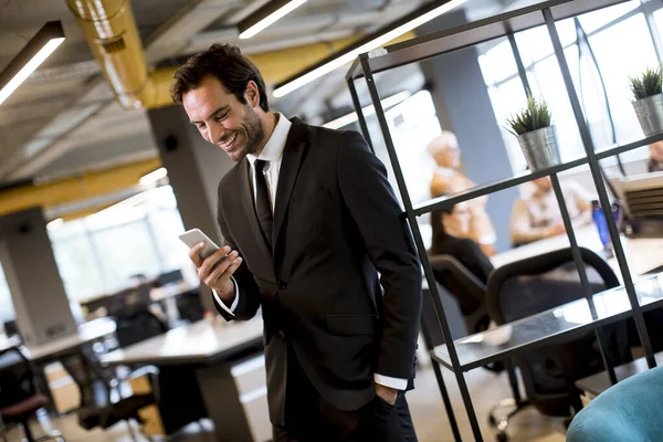 Snygg Ung Affärsman Bär Svart Kostym Med Modern Smartphone Kontoret — Stockfoto