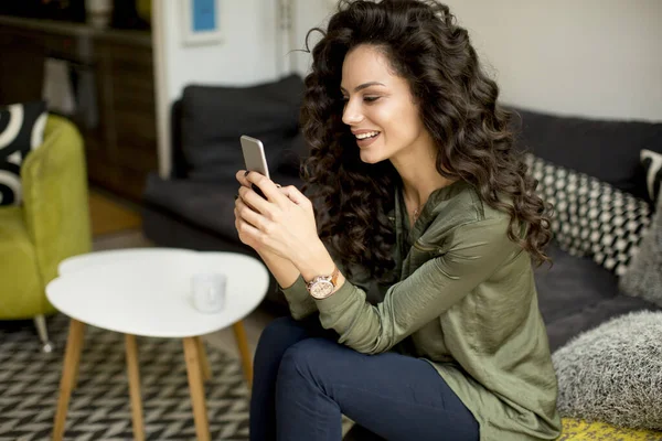 Mulher Bonita Com Cabelo Encaracolado Usando Telefone Celular Pela Janela — Fotografia de Stock