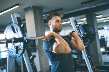 Spor salonunda koltuk değnekleriyle çalışan yakışıklı bir genç.