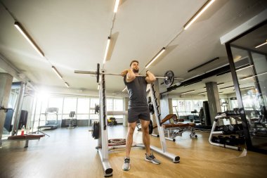 Spor salonunda koltuk değnekleriyle çalışan yakışıklı bir genç.