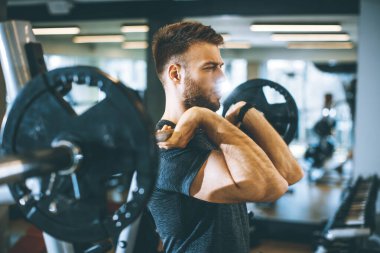 Spor salonunda koltuk değnekleriyle çalışan yakışıklı bir genç.