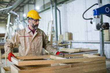 Mobilya fabrikasında çalışan yakışıklı olgun bir adam.