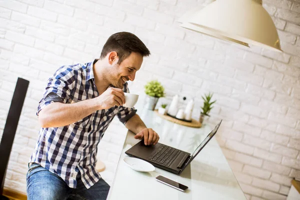 Knappe Jongeman Die Thuis Het Keukenbureau Zit Laptop Gebruikt Koffie — Stockfoto