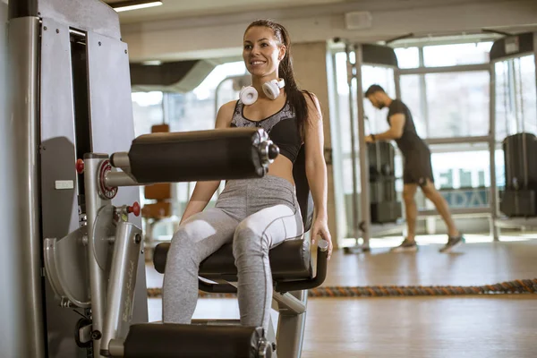 Ładna Młoda Kobieta Mając Ćwiczenia Wyprostowanie Nogi Nogi Curl Maszyny — Zdjęcie stockowe