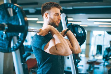 Spor salonunda koltuk değnekleriyle çalışan yakışıklı bir genç.