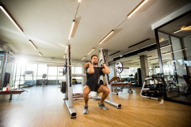 Spor salonunda koltuk değnekleriyle çalışan yakışıklı bir genç.