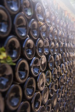 Birbirinin üstüne yığılmış boş eski şarap şişeleri.