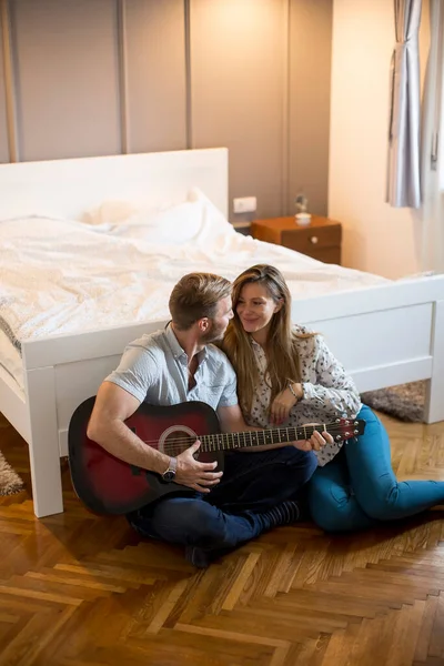 Namorado Está Tocando Guitarra Para Sua Bela Namorada Enquanto Sentado — Fotografia de Stock
