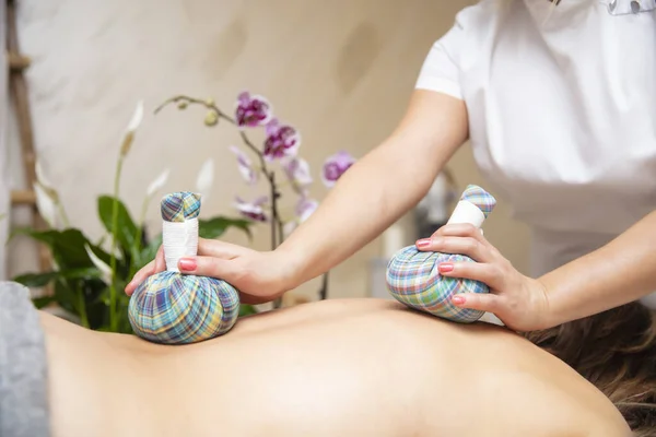 Rustige Jonge Vrouw Genieten Van Massage Met Kruidenzakken Spa — Stockfoto