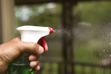 Virüslere karşı dezenfekte etmek için antibakteriyel sprey şişesinden püskürtülen ev temizliğine yakın çekim