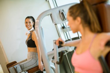 Güzel genç bir kadın spor salonunda çocuk kaçırma makinesi eğitimi alıyor.