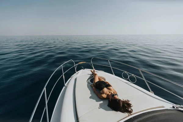 观看年轻迷人的女子在豪华游艇上轻松自在地漂浮在清澈的海面上 — 图库照片