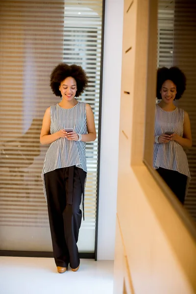Glimlachende Jonge Afrikaanse Amerikaanse Zakenvrouw Met Behulp Van Mobiele Telefoon — Stockfoto