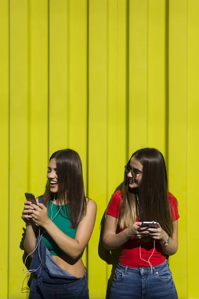 Unga Kvinnor Med Glad Ansikte Mot Gul Vägg Lyssna Musik — Stockfoto