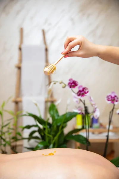 Jonge Vrouw Met Een Honing Terug Massage Spa Salon — Stockfoto