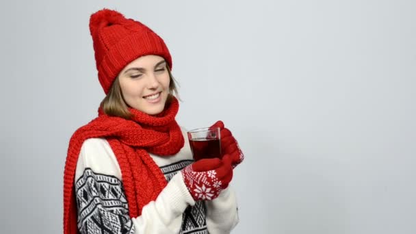 Зимняя девушка в красной теплой вязаной шляпе и шарфе с чашкой чая — стоковое видео
