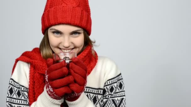 Chica de invierno en rojo cálido sombrero de punto y bufanda celebración taza de té — Vídeos de Stock