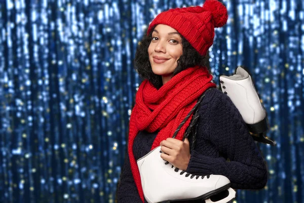 Mulher carregando um par de patins de gelo — Fotografia de Stock