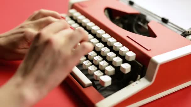Женщина вручную печатает на красной винтажной пишущей машинке — стоковое видео