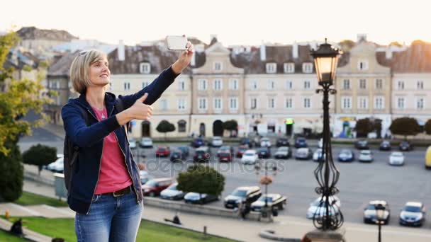 Turista mujer tomando una foto de una plaza de la ciudad — Vídeos de Stock