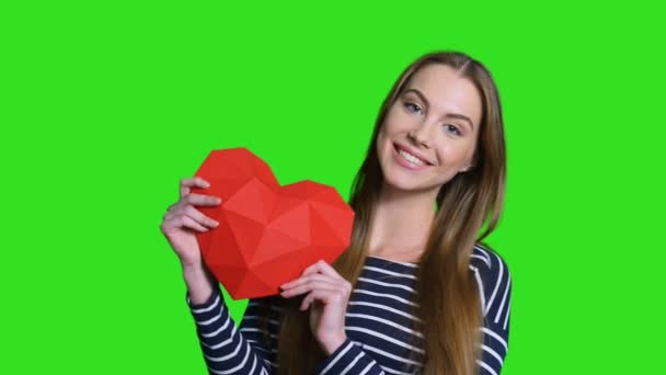 Donna sorridente che tiene la forma del cuore di carta poligonale rossa — Video Stock