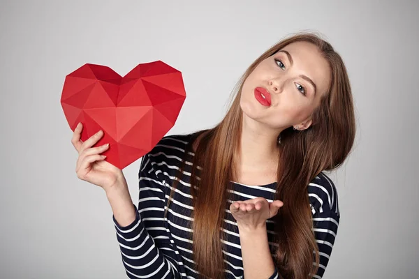 Lachende vrouw met rode veelhoekige papier hart vorm — Stockfoto