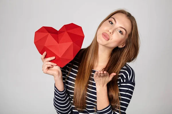 Smiling woman holding red polygonal paper heart shape — Stock Photo, Image
