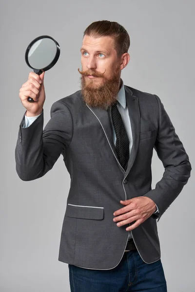 Homme d'affaires hipster sérieux avec loupe — Photo