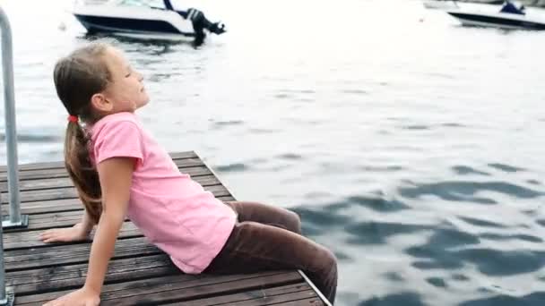 Little girl sitting on private pier — Stock Video