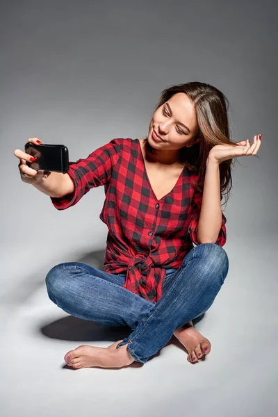 Smiling teen girl making self portrait on her smart phone — Stok Foto