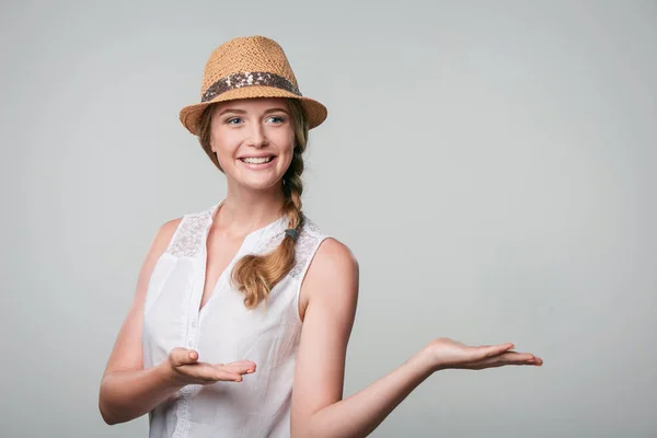 Mulher sorridente mostrando palma da mão aberta com espaço de cópia para produto ou texto — Fotografia de Stock