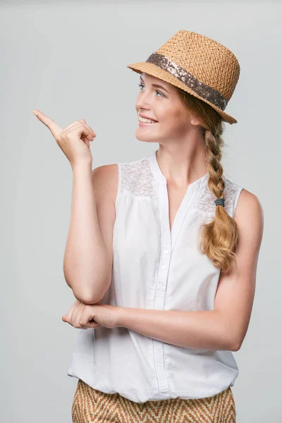 Femme souriante pointant vers le côté — Photo