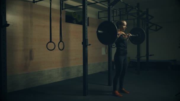 Hermosa joven entrenando con pesas en el gimnasio — Vídeos de Stock