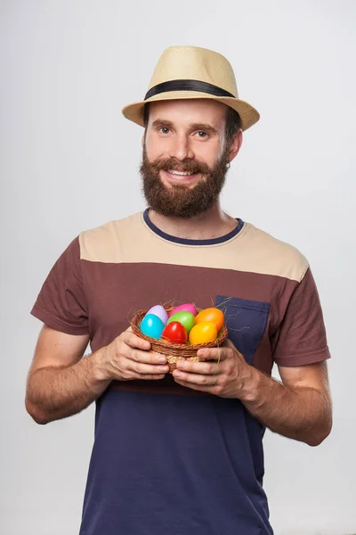 Homem barbudo segurando uma cesta com ovos de Páscoa — Fotografia de Stock