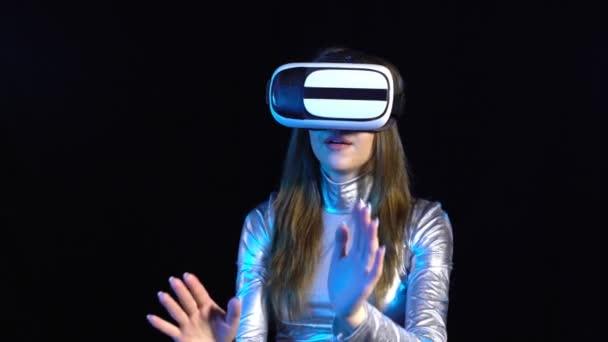 Mujer joven cibernética en ropa plateada con googles de realidad virtual — Vídeo de stock