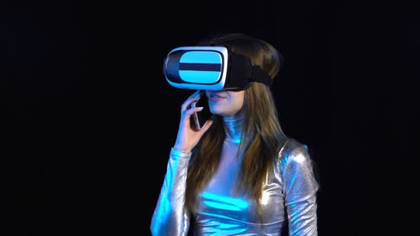 Mujer joven cibernética en ropa plateada con googles de realidad virtual — Vídeo de stock