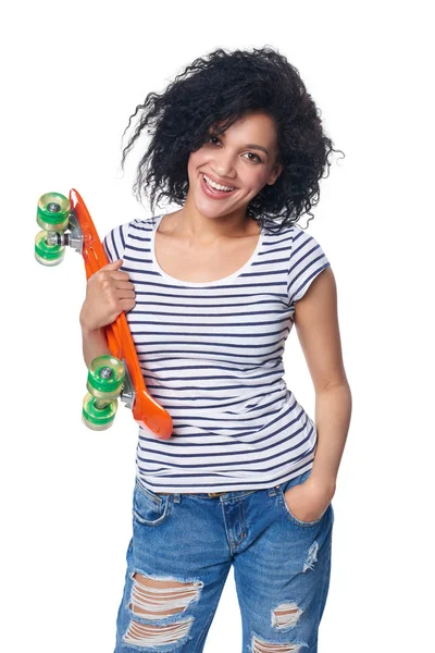 Feliz sorrindo mestiço feminino em jeans angustiados com skate — Fotografia de Stock