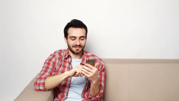 Young man with smartphone at home — Stock Video